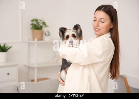 Giovane donna con il suo cane Biewer Terrier a casa Foto Stock