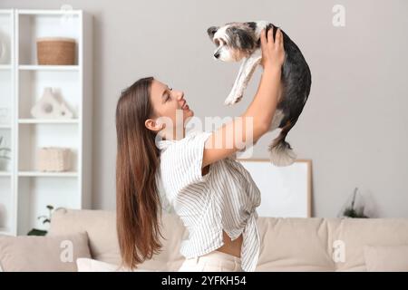 Giovane donna che tiene a casa il suo cane Biewer Terrier Foto Stock