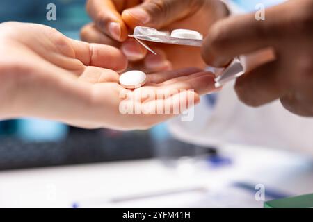 Medico che dà al paziente una pillola dalla compressa di medicina per iniziare il trattamento con i farmaci, raccomandando la giusta dose per il recupero. Il medico offre farmaci soggetti a prescrizione medica. Primo piano. Foto Stock