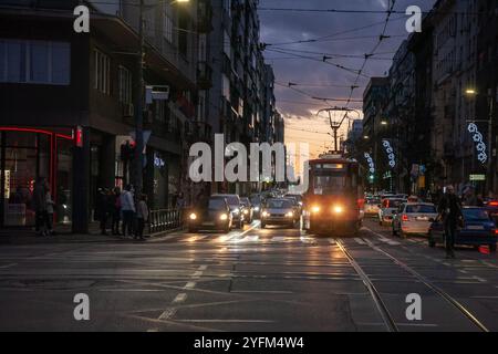 BELGRADO, SERBIA - 21 GENNAIO 2024: Tram e auto in attesa al semaforo di Belgrado. L'immagine illustra i trasporti urbani, incluso il pub Foto Stock
