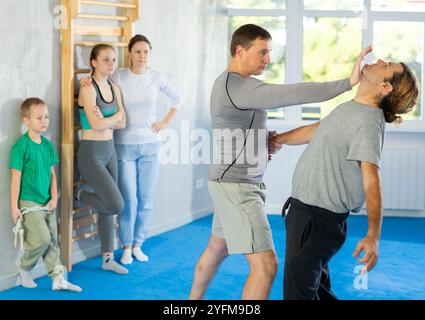 L'uomo in palestra esegue elementi di base del sistema di autodifesa krav maga. Foto Stock