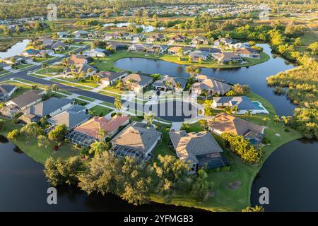 Vista aerea delle case private nell'area residenziale della Florida al tramonto. Nuove case familiari come esempio di sviluppo immobiliare nei sobborghi americani. Foto Stock