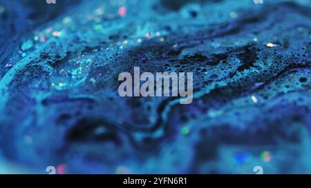 Consistenza della vernice a bolle. Flusso di liquido frizzante. Blu blu scuro particelle brillanti di colore nero schiuma umida pigmento d'acqua miscela liquida sfondo artistico astratto. Foto Stock