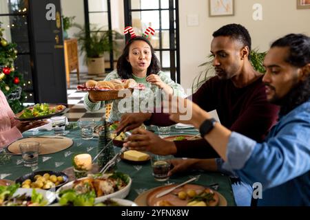 Natale, amici multirazziali che si godono una cena festiva, a casa Foto Stock