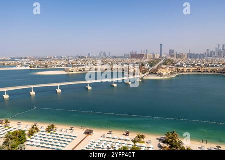 Paesaggio urbano di Dubai con moderni edifici per uffici, la struttura della monorotaia di palme al parco Aquaventure e lettini da sole sulla spiaggia dell'hotel Atlantis The Palm,2024 Foto Stock