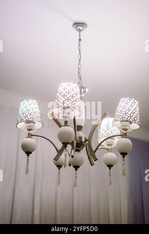 Elegante lampadario di lusso che illumina gli interni di una casa, aggiungendo un tocco di raffinatezza con un design complesso e un'illuminazione calda Foto Stock