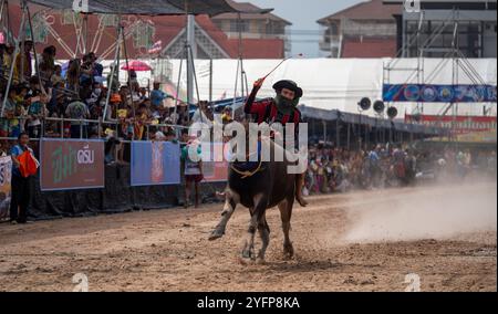 Un fantino cavalca un bufalo su una pista sterrata durante il 153° Festival annuale di Chonburi Buffalo Racing a Chonburi, Thailandia. Questa tradizione secolare Foto Stock