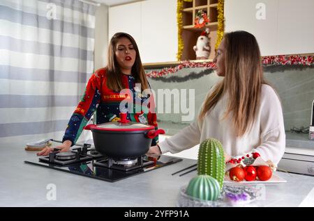 Due donne preparano insieme la cena di natale in una cucina moderna Foto Stock