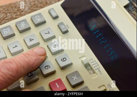 Pressione del dito sul tastierino di una calcolatrice Foto Stock