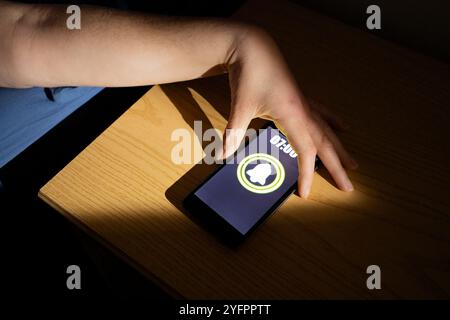 Donna si sveglia e spegne la sveglia sullo smartphone. Persona produttiva pronta per iniziare una giornata con opportunità di business. Primo piano sul phon mobile Foto Stock