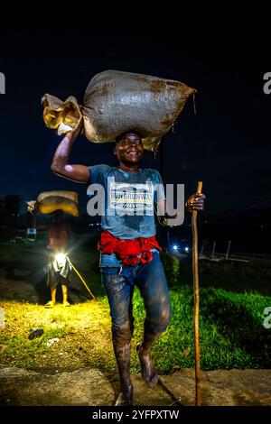 I bambini portano le ciliegie al caffè in una stazione di lavaggio del caffè, nel distretto di Rutsiro, nella provincia settentrionale, in Ruanda Foto Stock