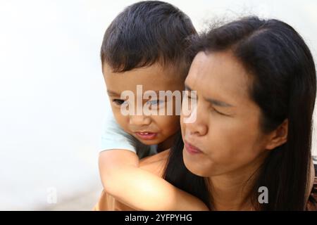 Un momento di gioia catturato tra una madre e suo figlio, che mostra il loro legame giocoso e il calore dell'amore di famiglia in un ambiente all'aperto. Foto Stock