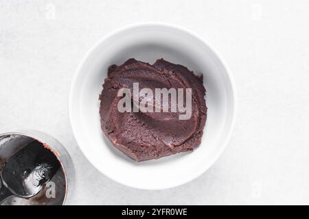 Vista dall'alto della pasta di fagioli rossi in una ciotola bianca, vista dall'alto della pasta dolce di fagioli adzuki in un piatto bianco, processo di preparazione dell'anko o della pasta di fagioli rossi Foto Stock