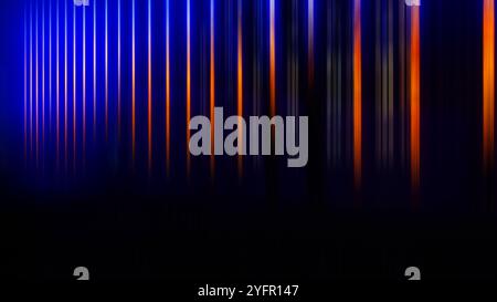 Sfondo sfocato astratto: Strisce colorate verticali parallele arancioni, chiare, blu su nero. Banner Web. Foto Stock