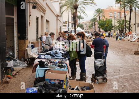 Paiporta, Valencia, Spagna - 4 novembre 2024. Effetti di DANA a Paiporta, l'epicentro del disastro, dove l'acqua dei burroni salì al livello delle strade causando inondazioni che coprivano le case degli abitanti. I commercianti furono distrutti dall'inarrestabile flusso di acqua e detriti. I binari della stazione della metropolitana sono appesi a diversi metri sopra il letto del burrone. Gli escavatori e i macchinari pesanti lavorano giorno e notte per accumulare macerie. La gente del posto porta fuori dalle proprie case tutti i mobili e gli effetti personali. Le forze militari arrivarono la notte del 2 novembre. Crediti: Roberto Arosio/Alamy Live News Foto Stock