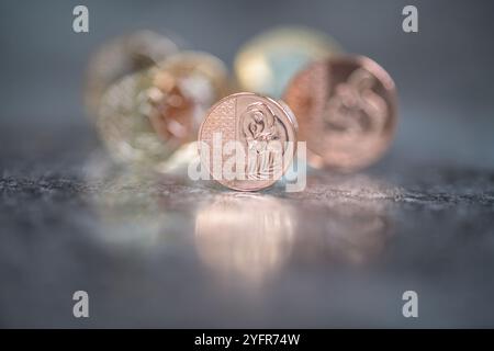 Sterling Coins, sua altezza reale Re Carlo III, in piedi su un top nero riflettente Foto Stock