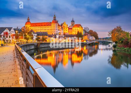 Neuburg an der Donau, Germania. Città vecchia con Sclohss Neuburg e alberi dai colori autunnali, riflesso sull'acqua del Danubio, splendida cittadina bavarese. Foto Stock