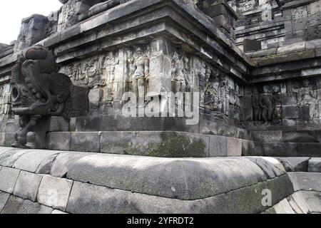 Sculture a bassorilievo sulla parete incassate a piedi di Borobudur, Indonesia Foto Stock