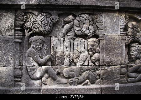 Sculture a bassorilievo sulla parete incassate a piedi di Borobudur, Indonesia Foto Stock