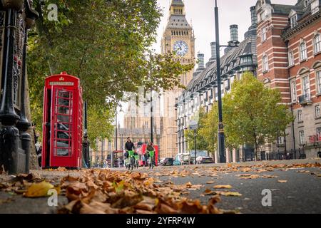 LONDRA - 30 OTTOBRE 2024: Scena di Westminster Street con iconica cabina telefonica rossa e Houses of Parliament Foto Stock