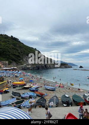 La spiaggia e i pescatori navigano in una nuvolosa giornata estiva a Monterosso al Mare, cinque Terre, Liguria, Italia Foto Stock