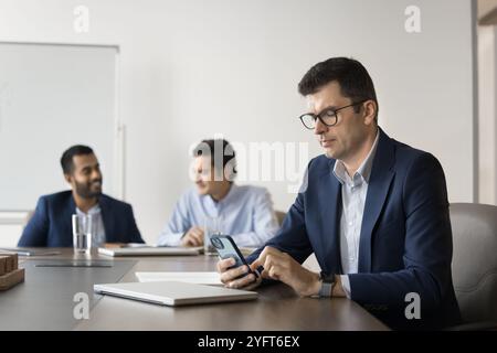 Un uomo serio leader dell'azienda caucasica che scrive su smartphone Foto Stock