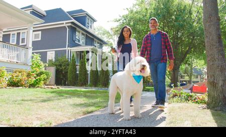 Tiro ad angolo basso di un cane da passeggio lungo Suburban Street Foto Stock
