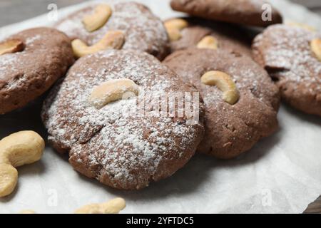 Deliziosi biscotti al cioccolato con anacardi e zucchero a velo sul tavolo, primo piano Foto Stock