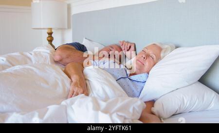 Tranquilla coppia senior che dorme nel letto a casa insieme Foto Stock