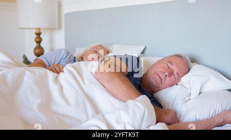 Tranquilla coppia senior che dorme nel letto a casa insieme Foto Stock