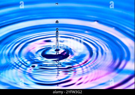 una goccia d'acqua che cade nell'acqua e crea onde Foto Stock
