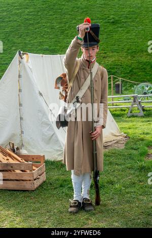 Reenactor in uniforme da fanteria di linea francese che carica moschetto napoleonico con muso al muso al campo di battaglia di Waterloo 1815, Braine-l'Alleud, Belgio Foto Stock