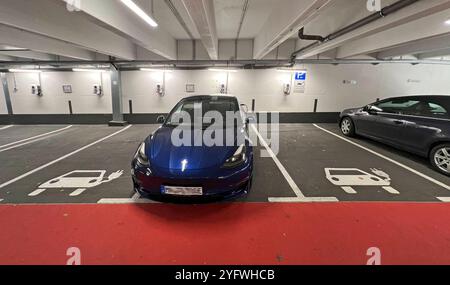 05.11.2024, Bad Ladesäule für, eine Wörishofen Unterallgäu e-Autos in der Tiefgarage. Ein blauer TESLA Model 3 steht beim Laden auf dem Parkplatz. 05.11.2024, Ladesäule 05.11.2024, Ladesäule *** 05 11 2024, Bad Wörishofen Unterallgäu, una stazione di ricarica per auto elettriche nel parcheggio sotterraneo Una TESLA Model 3 blu sta caricando nel parcheggio 05 11 2024, stazione di ricarica 05 11 2024, stazione di ricarica Foto Stock