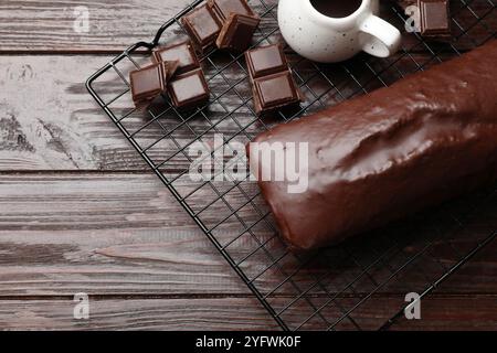 Gustosa torta di spugne e pezzi di cioccolato su un tavolo di legno, vista dall'alto Foto Stock