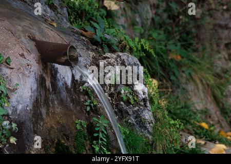 L'acqua scorre da un tubo di ferro arrugginito nella cascata di Alcoy, in Spagna Foto Stock