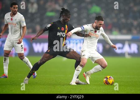 Vakoun Issouf Bayo di Watford e Matt Grimes di Swansea City (a destra) si battono per il pallone durante la partita del campionato Sky Bet allo stadio Swansea.com di Swansea. Data foto: Martedì 5 novembre 2024. Foto Stock