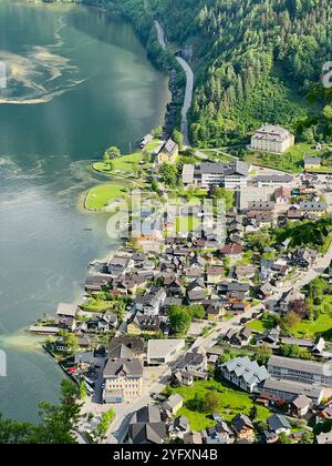 Una vista aerea che cattura un'affascinante cittadina sul lago annidata tra verdi colline e alberi a Hallstatt, Austria. L'ambiente tranquillo offre una vista panoramica Foto Stock