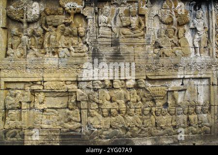 Sculture a bassorilievo sulla parete incassate a piedi di Borobudur, Indonesia Foto Stock