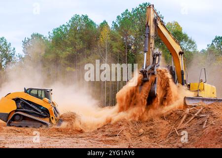 Un piccolo trattore movimento terra è in grado di livellare il terreno durante i lavori di costruzione in terra Foto Stock