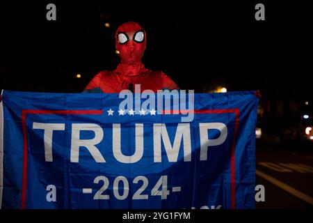 Una persona vestita da Spiderman tiene uno striscione con il testo “Trump 2024” in Black Lives Matter Plaza a Washington DC, USA martedì 5 novembre 2024. Foto Stock