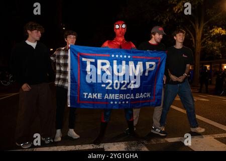 Una persona vestita da Spiderman tiene uno striscione con il testo “Trump 2024, Take America Back” in Black Lives Matter Plaza a Washington DC, USA martedì 5 novembre 2024. Foto Stock