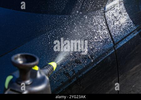 Lavaggio manuale dell'auto con prodotti chimici speciali per rimuovere lo sporco difficile dalla carrozzeria Foto Stock