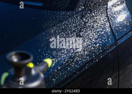 Lavaggio manuale dell'auto con prodotti chimici speciali per rimuovere lo sporco difficile dalla carrozzeria Foto Stock