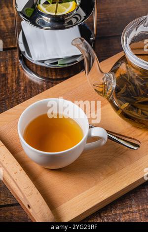 Tè alle erbe o tè al tiglio in porcellana bianca su un tavolo di legno Foto Stock