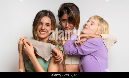 Gruppo moderno e variegato di giovani amici che ridono ed esprimono gioia - autentico ritratto dei giovani LGBTQ di Genz con espressioni naturali Foto Stock