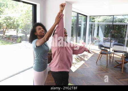 La donna sostiene il suo amico disabile mentre pratica yoga Foto Stock