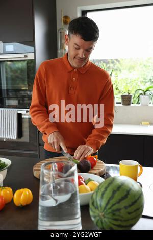 L uomo come tagliare le verdure in cucina Foto Stock