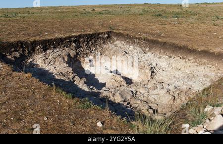 Fondo roccioso di una fossa archeologica scavata su una collina alla ricerca di manufatti storici Foto Stock