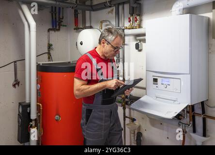 l'installatore controlla un moderno riscaldamento a gas Foto Stock