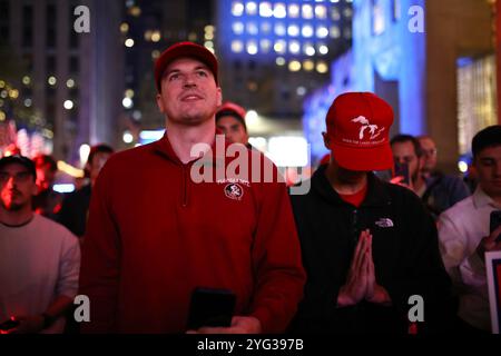 Il sostenitore di Trump prega per la sua rielezione a Rockefeller plaza, Manhattan, New York. Le elezioni presidenziali statunitensi che hanno visto il candidato democratico Kamala Harris contro il candidato repubblicano Donald Trump si sono svolte martedì 5 novembre. A New York, uno stato liberale che ha votato per il candidato democratico alle elezioni presidenziali dal 1988, gli elettori hanno seguito i risultati su Rockefeller Plaza man mano che arrivano tutta la notte. Con il progredire della serata, sempre più sostenitori di Trump si rallegrarono per gli stati vinti dal loro candidato. (Foto di Apolline Guillerot-Malick / SOPA Images/Sipa USA) Foto Stock